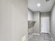 Functional laundry room featuring tiled floors, built-in shelving, and neutral paint at 20427 W Mountain Sage Dr, Buckeye, AZ 85326