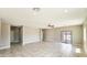 Open layout living room with tile flooring, ceiling fan, neutral paint, and a sliding glass door leading outside at 20427 W Mountain Sage Dr, Buckeye, AZ 85326