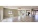 Open-concept living space with large windows, a ceiling fan, and tiled floors overlooking the kitchen at 20427 W Mountain Sage Dr, Buckeye, AZ 85326