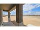 Covered porch with open views of the surrounding desert landscape on a sunny day at 20427 W Mountain Sage Dr, Buckeye, AZ 85326