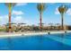 Resort-style swimming pool with palm trees, lounge chairs, and umbrellas providing a relaxing oasis at 20486 E Via Del Jardin --, Queen Creek, AZ 85142