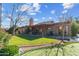 Expansive backyard featuring a putting green, mature landscaping, and a covered patio perfect for outdoor living at 2328 W Nopal Ave, Mesa, AZ 85202