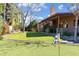Private backyard with putting green, a covered patio with outdoor seating, and mature trees at 2328 W Nopal Ave, Mesa, AZ 85202
