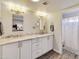Bright bathroom featuring a double sink vanity with granite countertops and white cabinets with modern lighting at 2328 W Nopal Ave, Mesa, AZ 85202