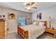 Cozy bedroom with natural wood accents, ceiling fan, carpet, and a comfortable bed at 2328 W Nopal Ave, Mesa, AZ 85202