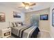 Comfortable bedroom with a ceiling fan, neutral walls, carpet, and a neatly made bed with decorative pillows at 2328 W Nopal Ave, Mesa, AZ 85202
