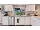 Bright kitchen with white cabinets, stainless steel appliances, and a window overlooking a lush backyard at 2328 W Nopal Ave, Mesa, AZ 85202
