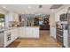 Updated kitchen with granite counters, white cabinets, stainless appliances, and open view to living area at 2328 W Nopal Ave, Mesa, AZ 85202