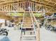Large garage interior featuring unfinished ceiling, overhead storage, and a sturdy wooden staircase at 2331 E Melrose St, Gilbert, AZ 85297