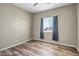 Cozy bedroom with a window, wood-look floors, and natural light at 23408 W Barwick Dr, Wittmann, AZ 85361
