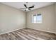 Neutral bedroom with wood-look floors, ceiling fan, and a bright window at 23408 W Barwick Dr, Wittmann, AZ 85361