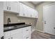 Laundry room with white cabinets, sink, countertop, and modern fixtures at 23408 W Barwick Dr, Wittmann, AZ 85361
