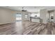 Open-concept living area with wood-look floors, ceiling fan, and access to the kitchen at 23408 W Barwick Dr, Wittmann, AZ 85361
