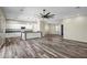 Open-concept living area with wood-look floors, ceiling fan, and modern kitchen at 23408 W Barwick Dr, Wittmann, AZ 85361