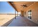 Covered outdoor patio features ceiling fans and a view of the expansive backyard at 23408 W Barwick Dr, Wittmann, AZ 85361