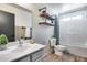 Bathroom with white vanity, sink, shelves, toilet and shower/tub at 23420 N 121St Ave, Sun City, AZ 85373