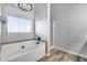 Bathroom featuring a soaking tub with tile accents and separate glass enclosed shower at 23420 N 121St Ave, Sun City, AZ 85373