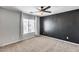 Bedroom with carpet, ceiling fan, window with curtains, and dark accent wall at 23420 N 121St Ave, Sun City, AZ 85373