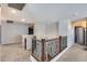 Upstairs hallway with carpet, wood and iron railing, and modern light fixture at 23420 N 121St Ave, Sun City, AZ 85373