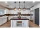 Gourmet kitchen boasts custom island, white cabinetry, stainless appliances, and stylish backsplash at 23420 N 121St Ave, Sun City, AZ 85373