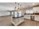 Modern kitchen boasts center island, white cabinetry, stainless appliances, and stylish backsplash at 23420 N 121St Ave, Sun City, AZ 85373