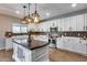Modern kitchen boasts center island, white cabinetry, stainless appliances, and stylish backsplash at 23420 N 121St Ave, Sun City, AZ 85373