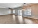 Open-concept living room with hardwood floors, modern light fixture, and sliding glass doors to the backyard at 23420 N 121St Ave, Sun City, AZ 85373