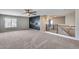 Spacious carpeted living room featuring a ceiling fan, wall decor, and bright lighting at 23420 N 121St Ave, Sun City, AZ 85373