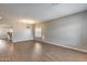 Open living room with wood flooring, an elegant light fixture, and large windows at 23420 N 121St Ave, Sun City, AZ 85373