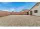 Wide view of the backyard with gravel, privacy wall, and covered patio at 24009 W Antelope Trl, Buckeye, AZ 85326