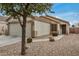 Beige single-story home featuring desert landscaping, a two-car garage, and a welcoming entrance at 24009 W Antelope Trl, Buckeye, AZ 85326