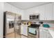 The kitchen showcases stainless steel appliances, white cabinetry and plenty of counter space at 24009 W Antelope Trl, Buckeye, AZ 85326