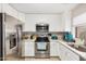 This bright kitchen includes stainless steel appliances, white cabinets, and light countertops at 24009 W Antelope Trl, Buckeye, AZ 85326