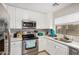 Bright kitchen features white cabinets, stainless steel appliances, and a well-lit sink area at 24009 W Antelope Trl, Buckeye, AZ 85326