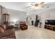 Comfortable living room with tile floors, neutral paint, wood accents, and a ceiling fan at 24009 W Antelope Trl, Buckeye, AZ 85326