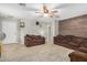 Cozy living room with tile floors, neutral paint, wood accent wall, and a ceiling fan at 24009 W Antelope Trl, Buckeye, AZ 85326