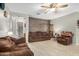 Bright living room with tile floors, neutral walls, wood accent wall and a ceiling fan at 24009 W Antelope Trl, Buckeye, AZ 85326