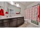 Bathroom featuring a dark vanity, tile flooring, and shower with strawberry themed curtain at 30935 W Mulberry Dr, Buckeye, AZ 85396
