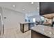 Well-lit kitchen featuring stainless steel appliances, granite countertops, and a view of the dining area at 30935 W Mulberry Dr, Buckeye, AZ 85396