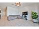 Comfortable living room featuring a gray couch, a ceiling fan, and a view of the kitchen at 30935 W Mulberry Dr, Buckeye, AZ 85396