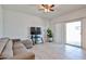 Inviting living room featuring a plush couch, a ceiling fan, and sliding glass doors at 30935 W Mulberry Dr, Buckeye, AZ 85396