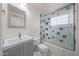 Cozy bathroom featuring a tiled tub with sliding glass doors, a standard sink, and a mirrored vanity at 3317 N 10Th Ave, Phoenix, AZ 85013