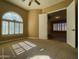Bright bedroom with neutral carpet, ceiling fan, large window, and open door at 3840 E San Mateo Way, Chandler, AZ 85249