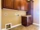 Convenient laundry room with cabinets, countertop, and tiled floor at 3840 E San Mateo Way, Chandler, AZ 85249