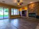Bright living room boasts a stone fireplace, ceiling fan, and a glass door to the outside at 3840 E San Mateo Way, Chandler, AZ 85249