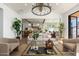 Open-concept living area with hardwood floors, neutral furniture, plants, high ceilings, and a view of the kitchen at 3913 E Campbell Ave, Phoenix, AZ 85018