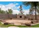Spacious backyard with desert landscaping, stone fireplace, brick accents, and mature trees at 4254 S Winter Ln, Gilbert, AZ 85297