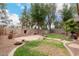 Lush backyard with a stone fireplace, mature trees, desert landscaping, and a large patio at 4254 S Winter Ln, Gilbert, AZ 85297
