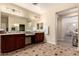 Spacious bathroom featuring double sinks, dark wood cabinets, and a decorative tile floor at 4254 S Winter Ln, Gilbert, AZ 85297