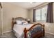 Cozy bedroom with a wooden bed frame, soft carpet, and natural light from the window at 4254 S Winter Ln, Gilbert, AZ 85297
